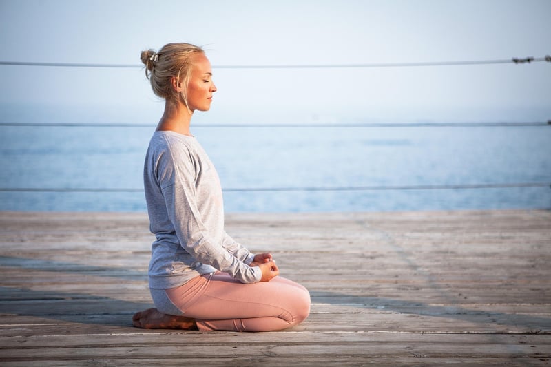 Woman meditating at sunrise